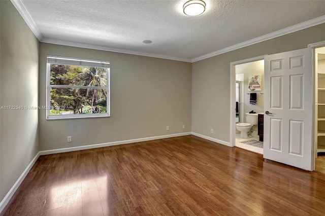 unfurnished room with dark wood-type flooring, ornamental molding, and a textured ceiling