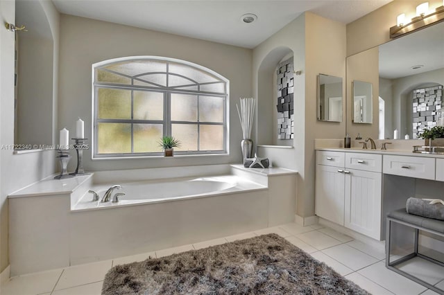 bathroom with vanity, a bathing tub, and tile patterned flooring