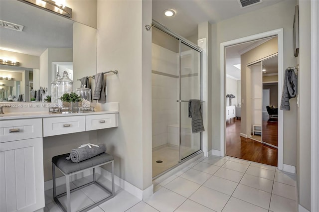 bathroom with tile patterned flooring, vanity, and walk in shower