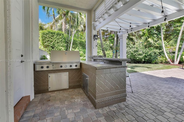 view of patio featuring grilling area, a pergola, exterior kitchen, and sink