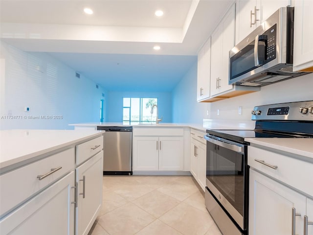 kitchen with white cabinets, light tile patterned floors, sink, and appliances with stainless steel finishes