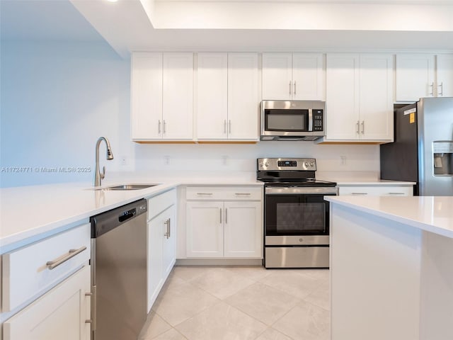 kitchen featuring sink, white cabinets, stainless steel appliances, and light tile patterned floors