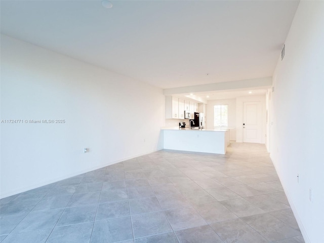 unfurnished living room with sink and light tile patterned flooring