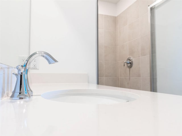 bathroom with a tile shower and sink