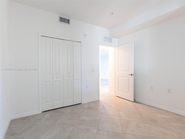 unfurnished bedroom featuring a closet and light tile patterned flooring