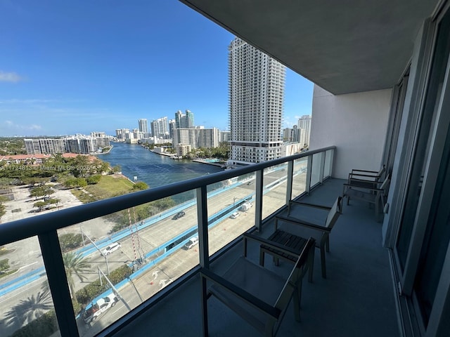 balcony with a water view and a view of city