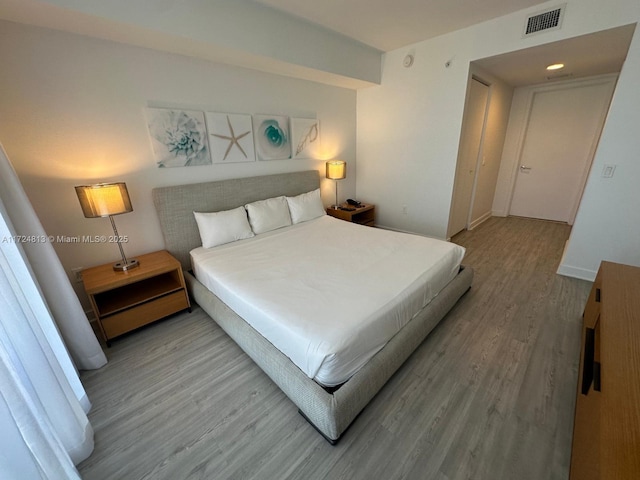 bedroom featuring visible vents, baseboards, and wood finished floors