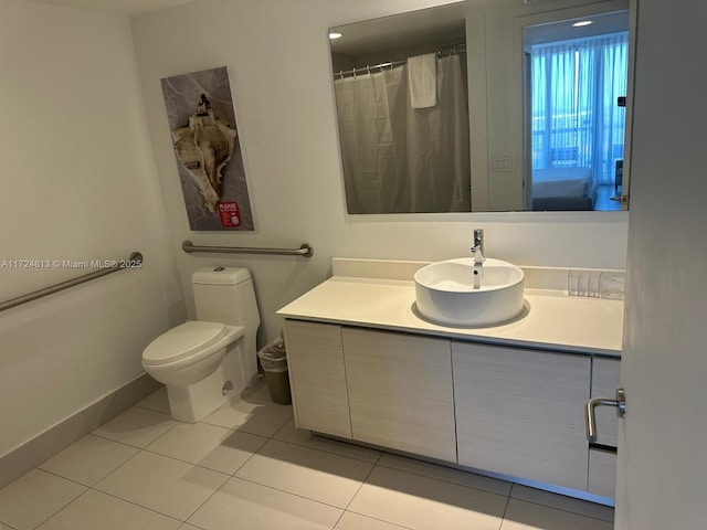 full bathroom with toilet, baseboards, vanity, and tile patterned floors