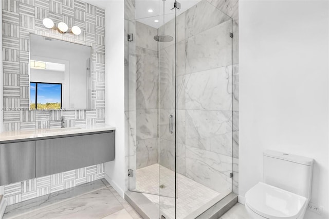 bathroom featuring vanity, a shower with door, and toilet