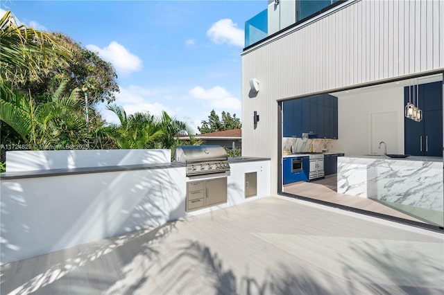 view of patio / terrace featuring an outdoor kitchen, grilling area, and sink