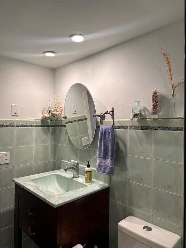 bathroom featuring tile walls, toilet, and vanity