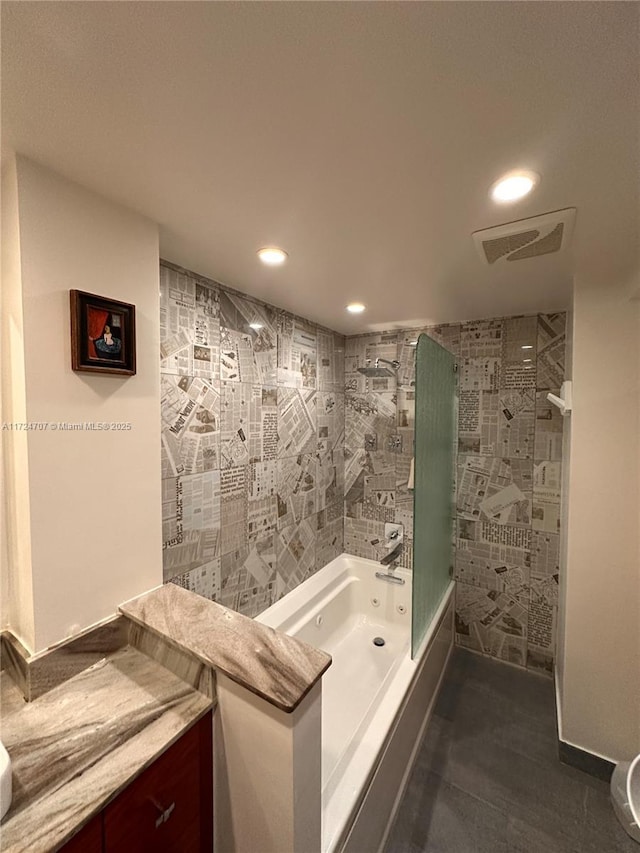 bathroom featuring vanity and tiled shower / bath