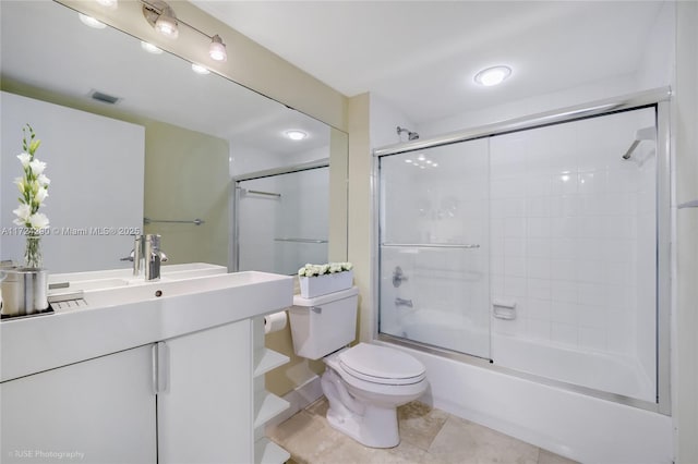 full bathroom featuring combined bath / shower with glass door, tile patterned floors, vanity, and toilet