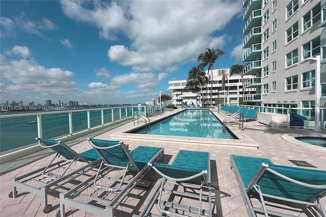 view of swimming pool with a community hot tub and a patio area