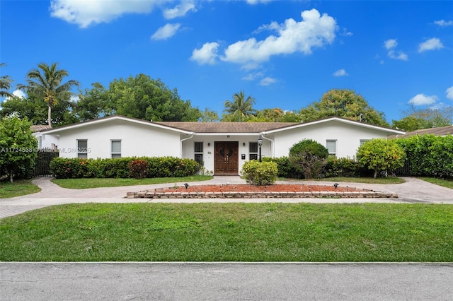 ranch-style home with stucco siding, a front yard, and fence