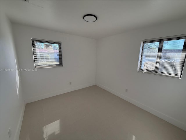 tiled empty room featuring plenty of natural light