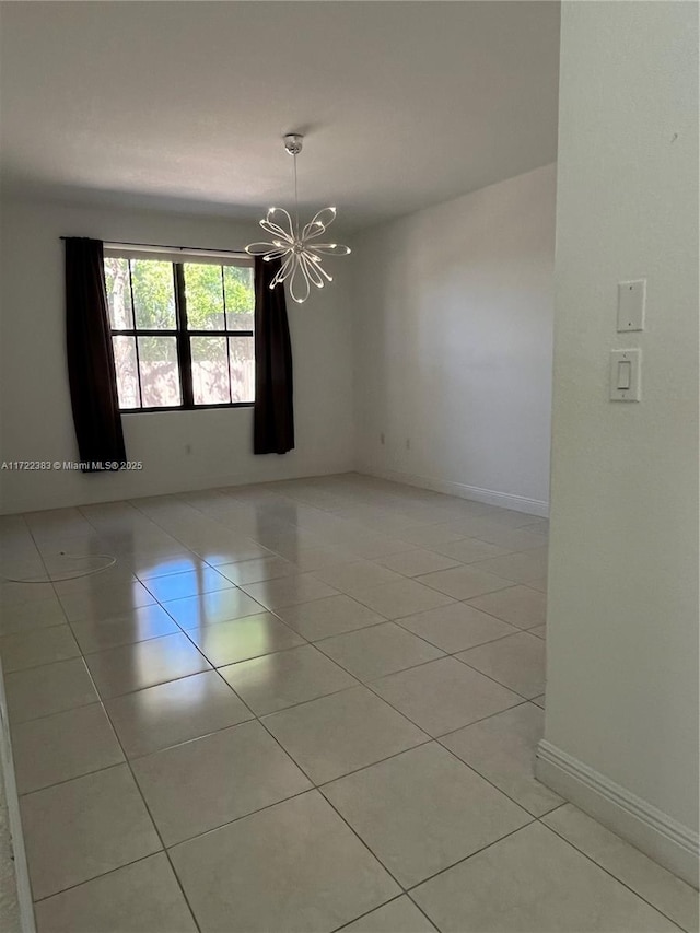 spare room featuring an inviting chandelier and light tile patterned flooring