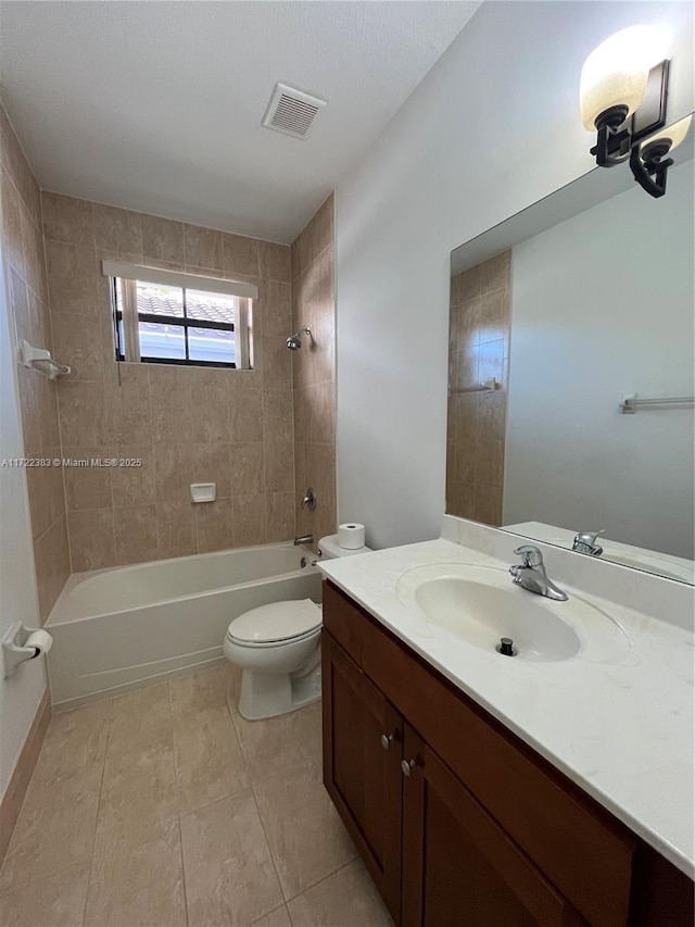 full bathroom featuring tiled shower / bath, vanity, toilet, and tile patterned flooring