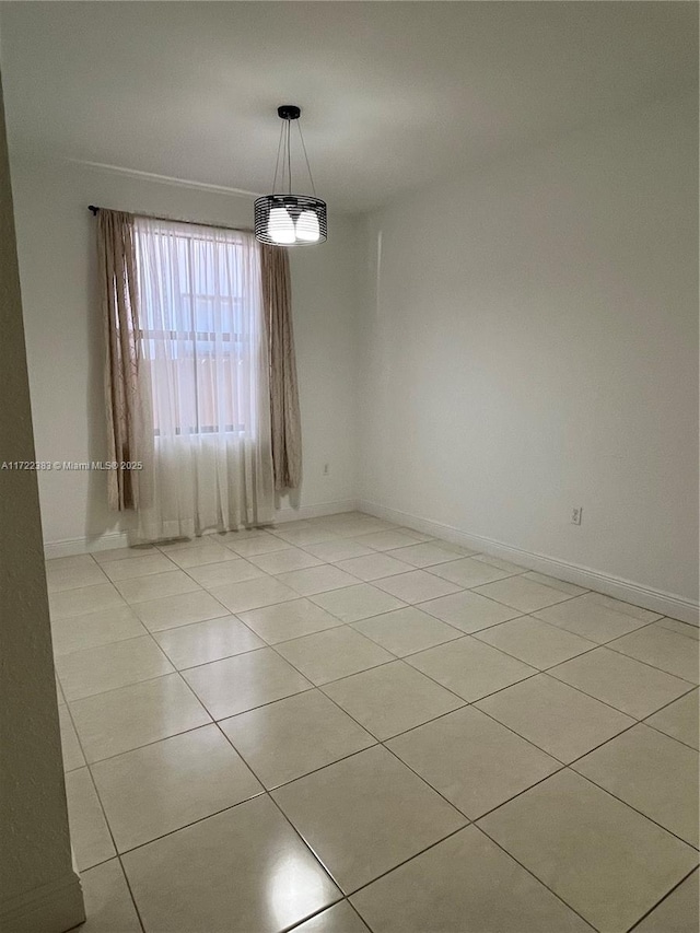 unfurnished room featuring an inviting chandelier and light tile patterned floors