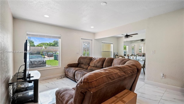 living room featuring a textured ceiling and ceiling fan