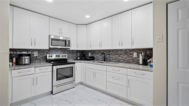 kitchen with white cabinets, appliances with stainless steel finishes, and sink