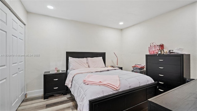 bedroom with light hardwood / wood-style flooring and a closet