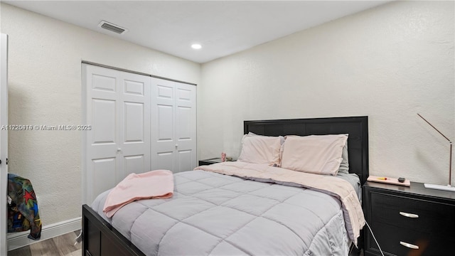 bedroom with hardwood / wood-style floors and a closet