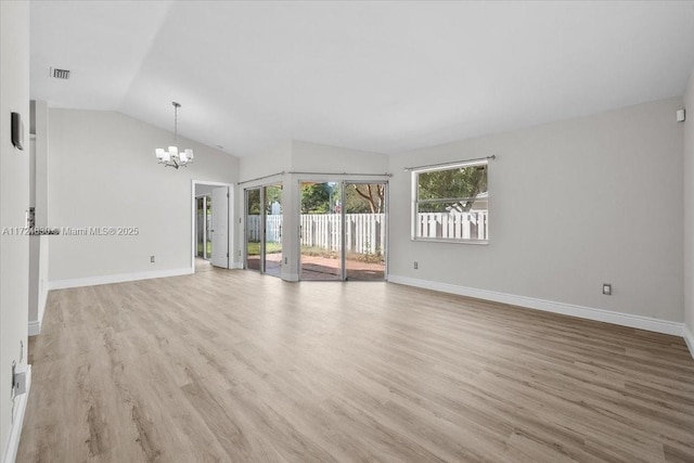 unfurnished room featuring light hardwood / wood-style floors, lofted ceiling, and a notable chandelier