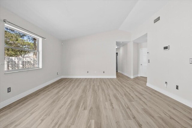 empty room featuring light hardwood / wood-style floors and lofted ceiling