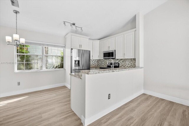 kitchen with white cabinetry, light stone counters, light hardwood / wood-style flooring, decorative backsplash, and appliances with stainless steel finishes