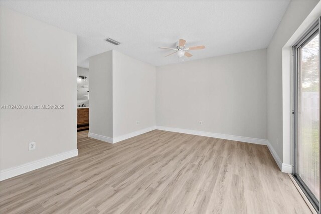 spare room with ceiling fan, light hardwood / wood-style floors, and a textured ceiling