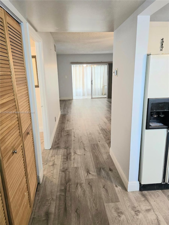 hallway featuring a textured ceiling and light wood-type flooring