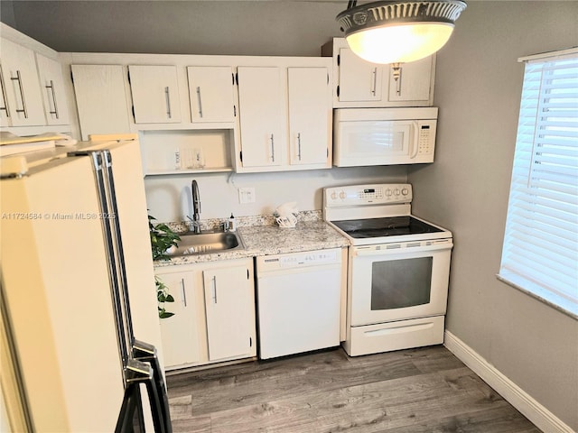 kitchen featuring white cabinets, wood-type flooring, white appliances, and sink