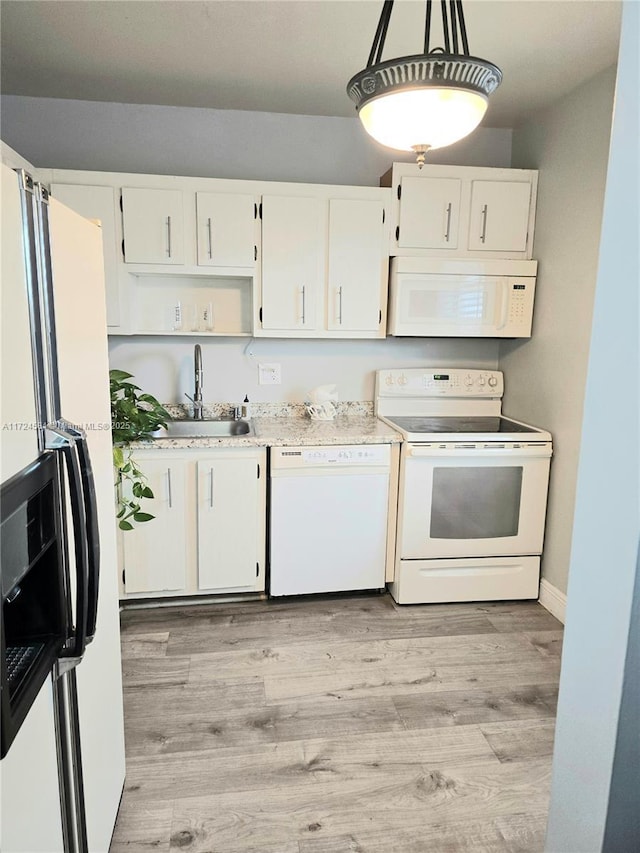 kitchen featuring white appliances, white cabinets, sink, light wood-type flooring, and decorative light fixtures