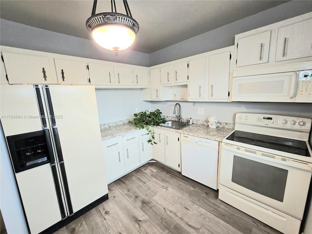 kitchen with white appliances, sink, hanging light fixtures, light hardwood / wood-style flooring, and white cabinetry