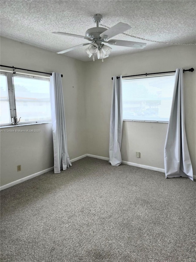 spare room with carpet flooring, ceiling fan, and a textured ceiling