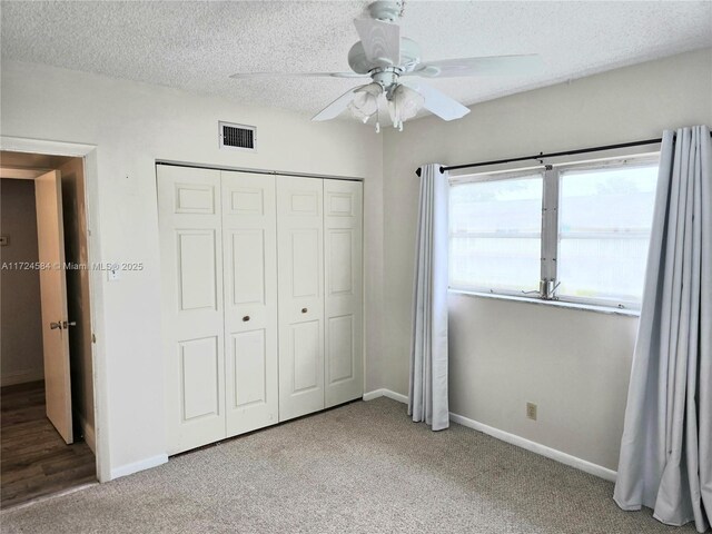 carpeted spare room featuring ceiling fan and a textured ceiling