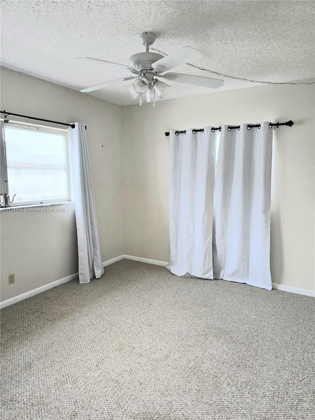 unfurnished room featuring ceiling fan, carpet, and a textured ceiling