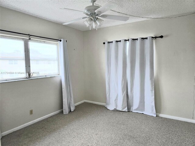 spare room featuring ceiling fan, carpet floors, and a textured ceiling