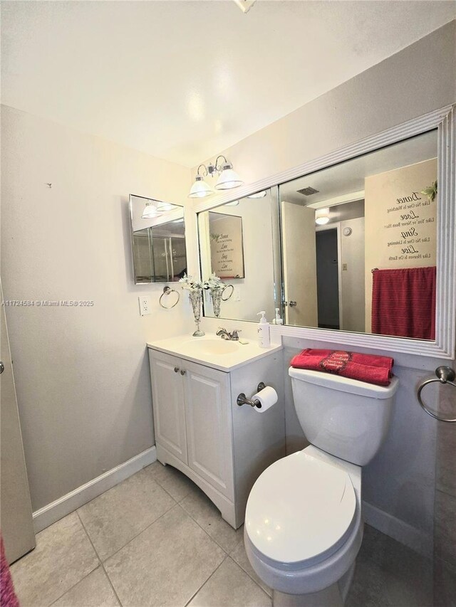 bathroom featuring tile patterned flooring, vanity, toilet, and a chandelier