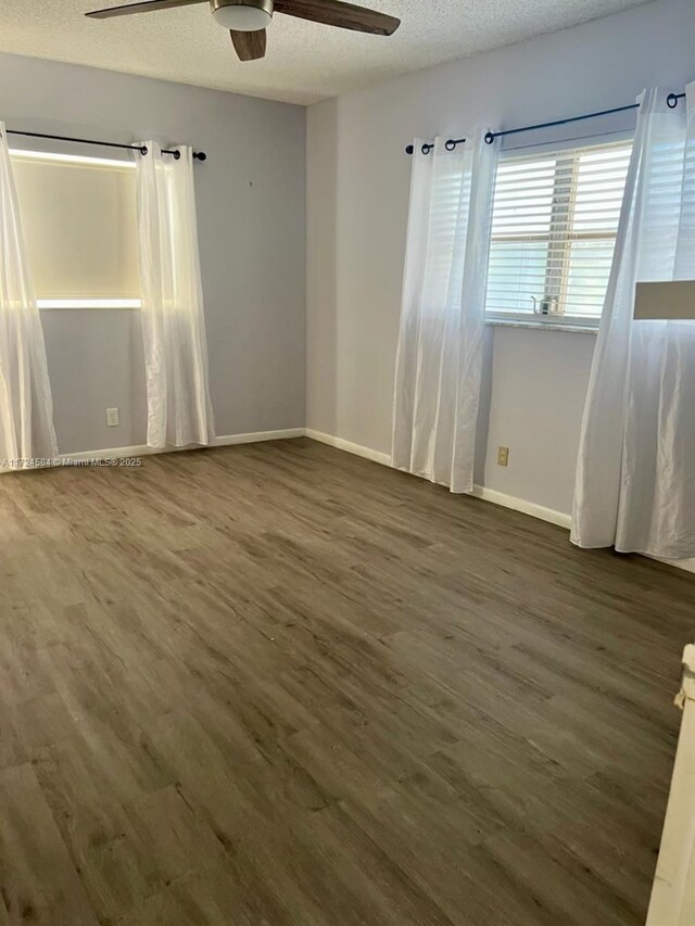 empty room with hardwood / wood-style flooring, ceiling fan, and a textured ceiling