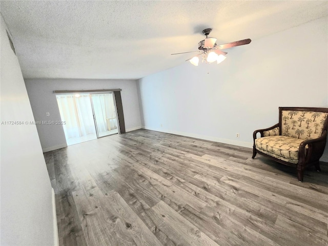 unfurnished room featuring ceiling fan, a textured ceiling, and light wood-type flooring