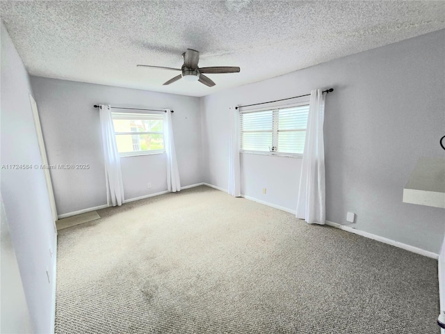 unfurnished room featuring carpet, ceiling fan, and a textured ceiling