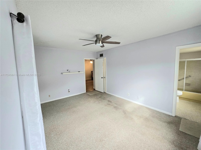 unfurnished bedroom featuring a textured ceiling, connected bathroom, carpet floors, and ceiling fan