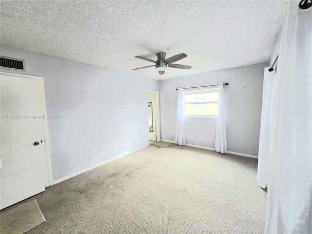 carpeted spare room with a textured ceiling and ceiling fan