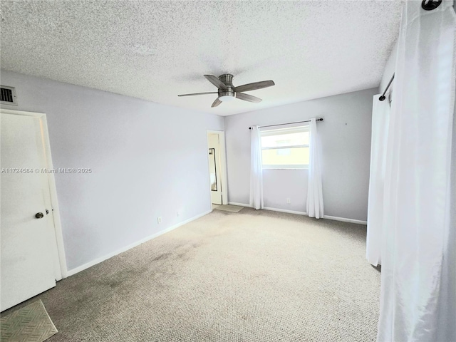 empty room with ceiling fan, carpet, and a textured ceiling