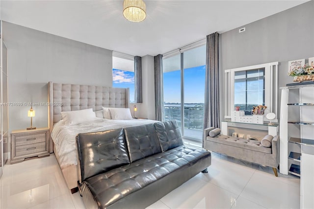 bedroom with access to outside, tile patterned floors, and a wall of windows