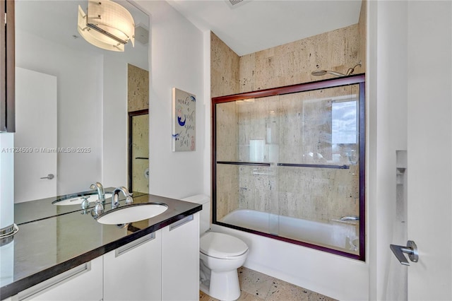 full bath with toilet, vanity, and combined bath / shower with glass door