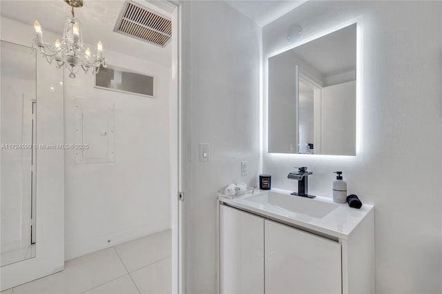 bathroom featuring tile patterned flooring, vanity, electric panel, and a notable chandelier