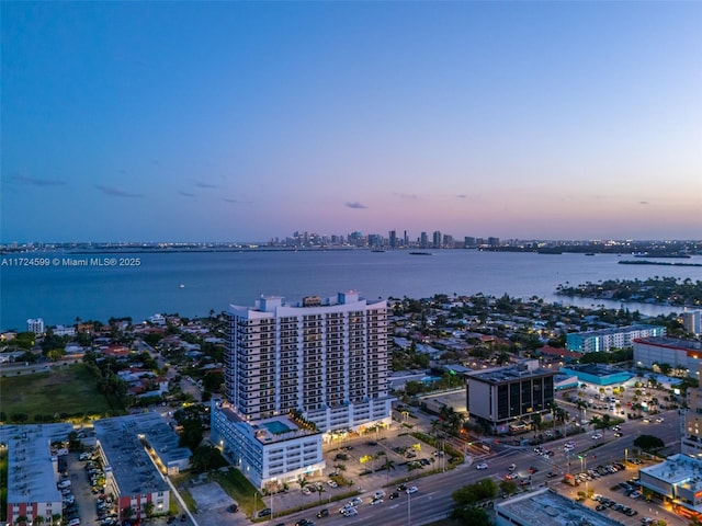 aerial view at dusk with a city view and a water view